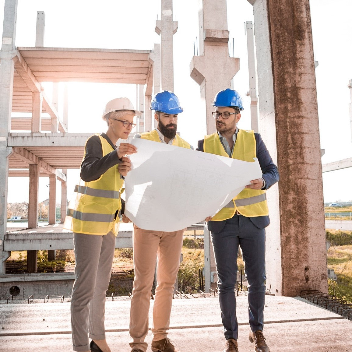 Drei Architekten begutachten einen Bauplan