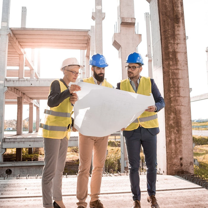 Drei Architekten begutachten einen Bauplan