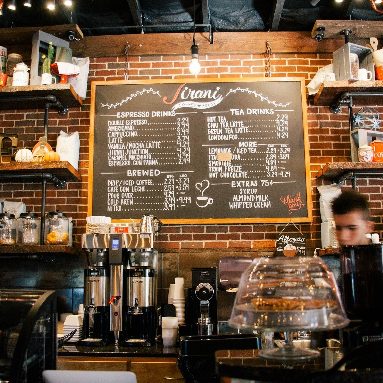 Ein Mitarbeiter steht hinter der Theke eines Cafés