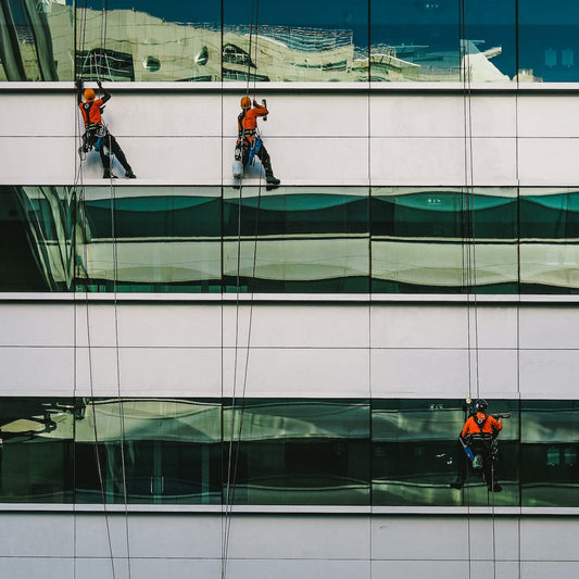 Arbeiter hängen an der Fassade eines Gebäudes