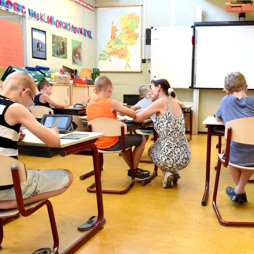 Kinder beugen sich in einer Grundschule konzentriert über ihre Tische