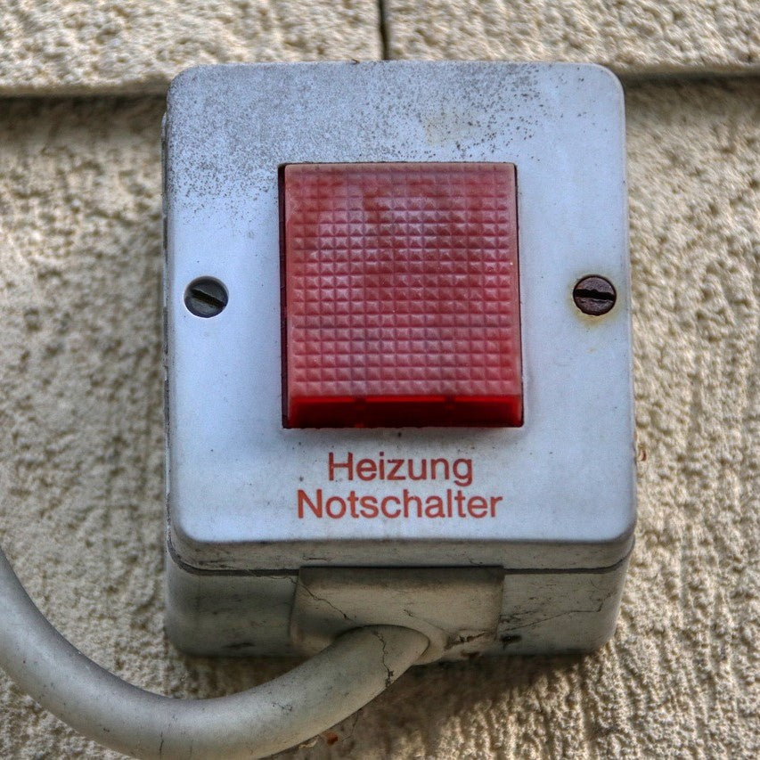 Ein Heizungs-Notschalter mit rotem Knopf