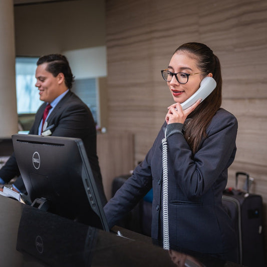 Eine Angestellte steht telefonierend in einem Hotel